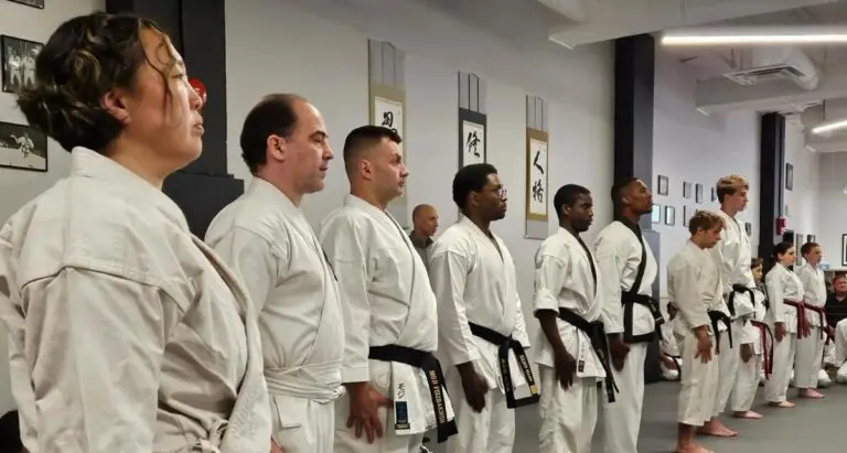 Martial arts students standing in formation during belt ranking practice inside the dojo.