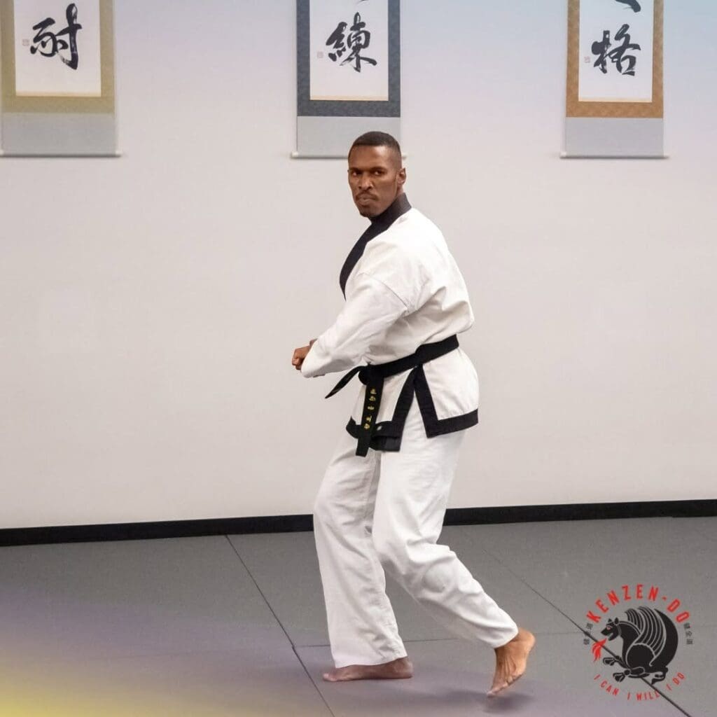 A taekwondo instructor demonstrating a formal stance and technique during class, showing what to expect in taekwondo class.