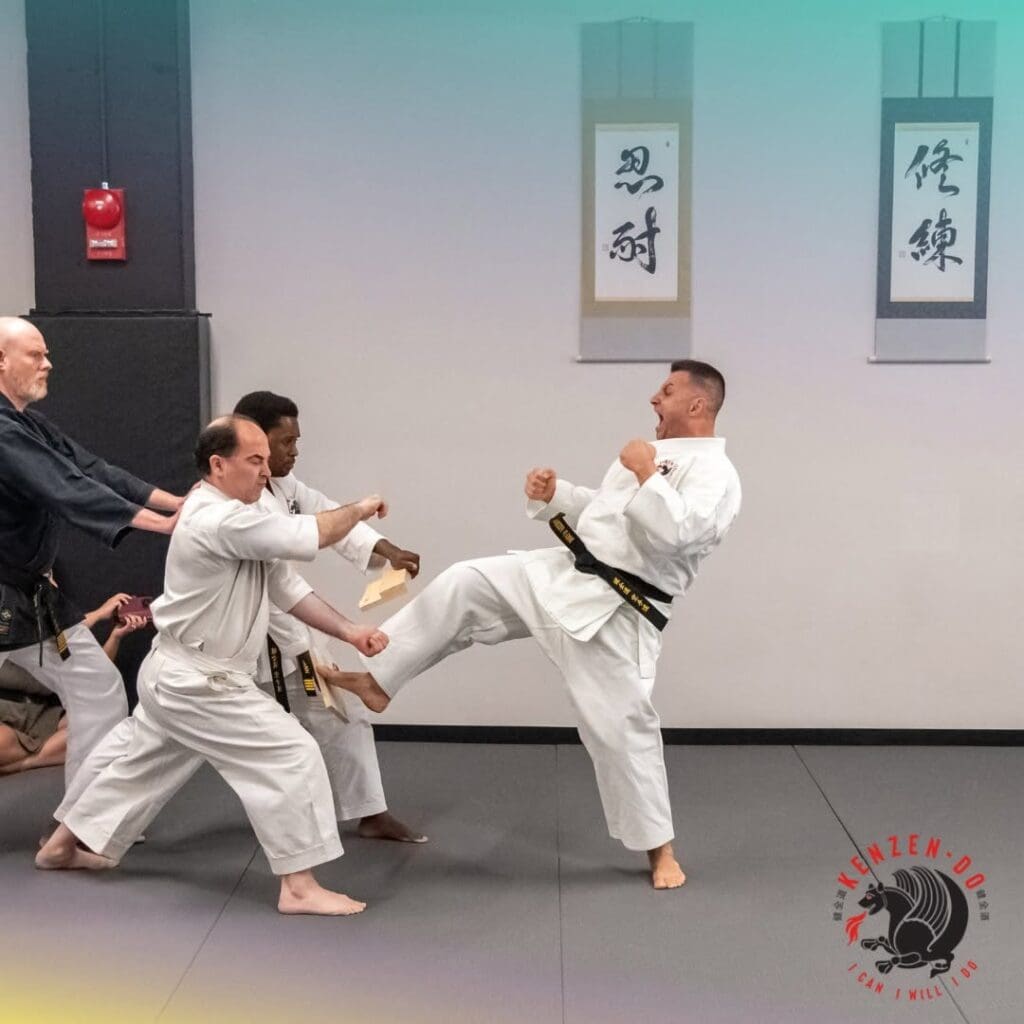 Martial artist breaks a board during taekwondo accuracy drills in class